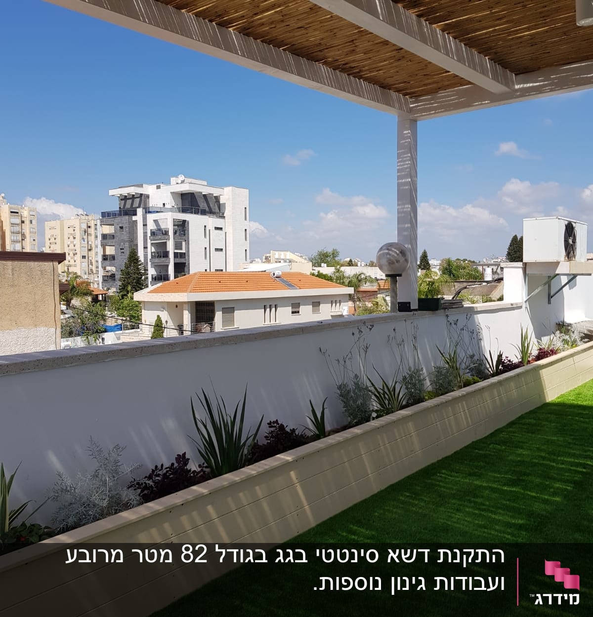 צמחים ירוקים בערוגה על מרפסת עם דשא סינתטי